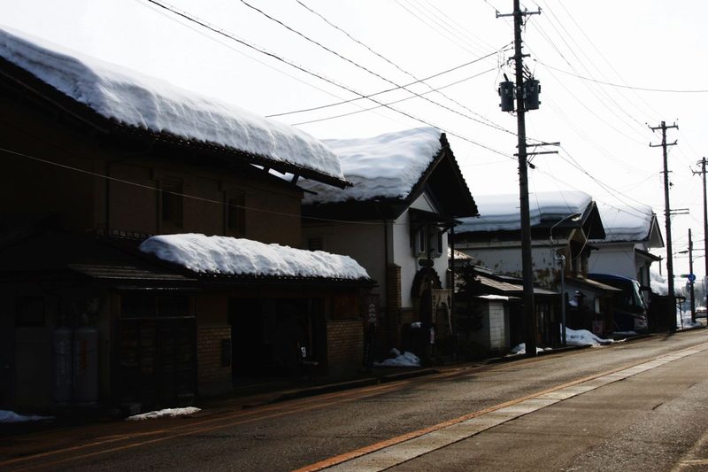 雪が積もった喜多方の通りと、古い蔵造りの家並み